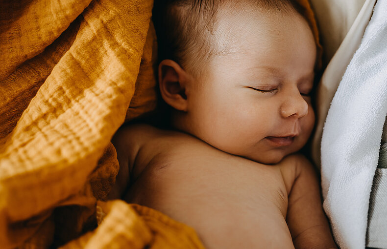 Closeup of a newborn baby dreaming and smiling while sleeping. afbeelding Contact