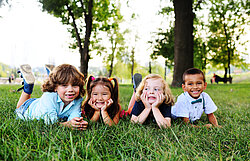 friends of preschool kids playing lying on the grass in the Park on a summer day friends of preschool kids playing lying on the grass in the Park on a summer day